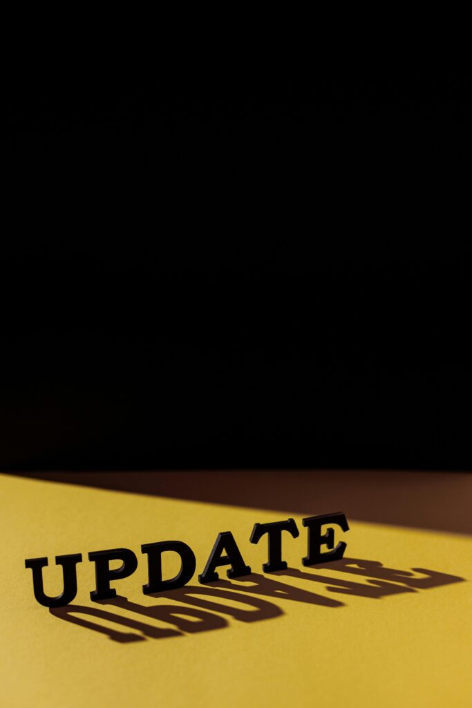 Word 'UPDATE' casting shadow on yellow background. Creative typography concept.